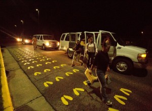Young men and women from across the country rush from vans onto the famous yellow footprints Sept. 22, 2014, on Parris Island, S.C (Photo by Cpl. Caitlin Brink)