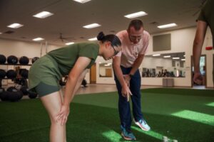 Sports Medicine Injury Prevention Trainer Jay Gibson assists a recruit. (U.S. Marine Corps Photo by Sgt. Ryan Hageali)
