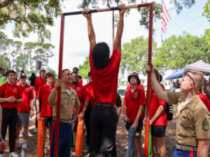 A Vero Beach High School student attempts the Marine Corps pull up bar challenge during the Lakeside Jazz Festival held at Port Orange, Florida. (U.S. Marine Corps photo by Lance Cpl. Kevin Lopez Herrera)